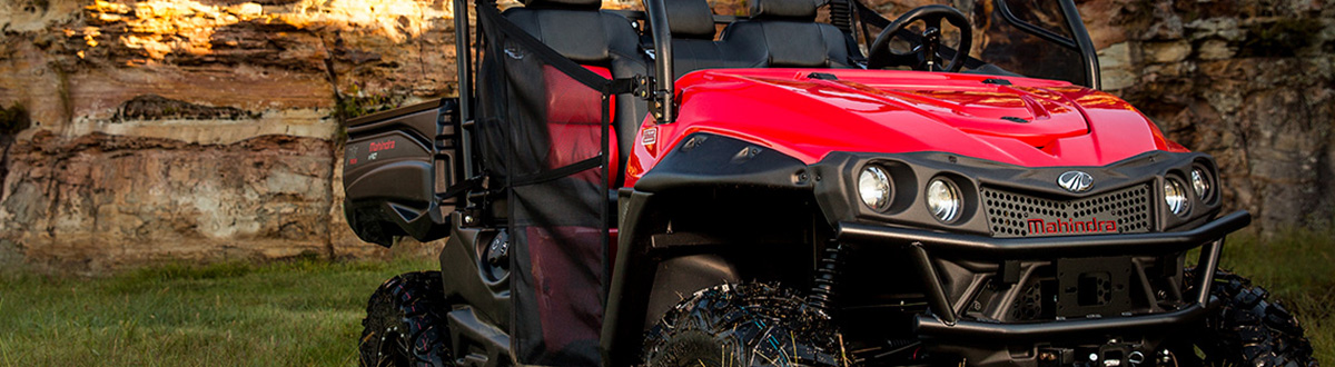 Mahindra® mPact XTV-750-S parked next to a natural rock wall in the evening.